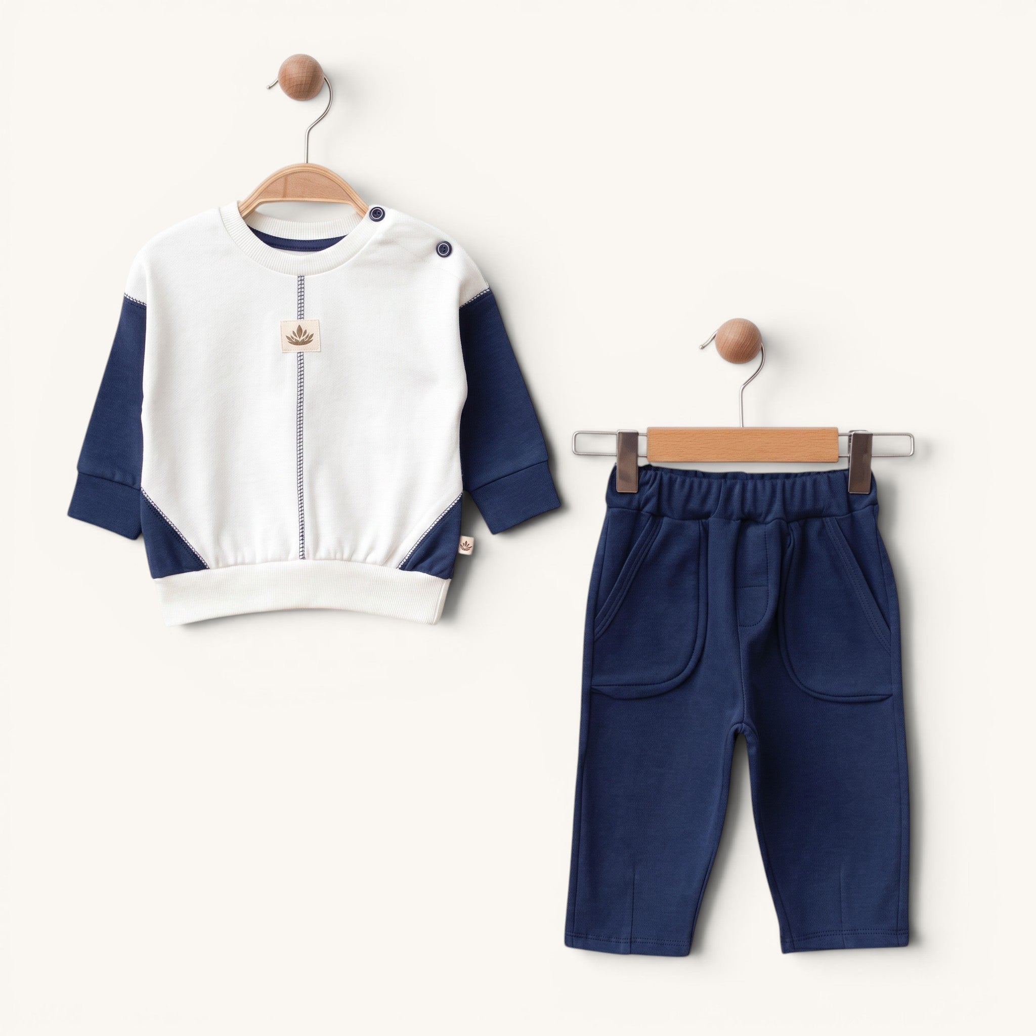 Loumi Baby lacivert ve beyaz renkli, %100 organik pamuklu, omuzdan düğmeli bebek sweatshirt ve pantolon ikili takım